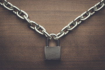Fototapeta na wymiar check-lock and chain on wooden background concept