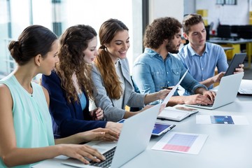 Smiling business team working on laptop 