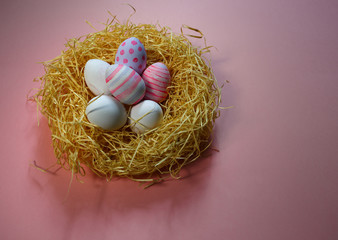 Naklejka na ściany i meble Colorful vintage easter eggs in nest on pink background