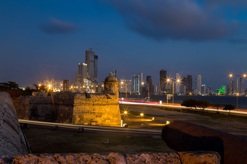 Fototapeta na wymiar Blue hour long exposure view of Cartagena's colonial wall and Bocagrande in the distance.