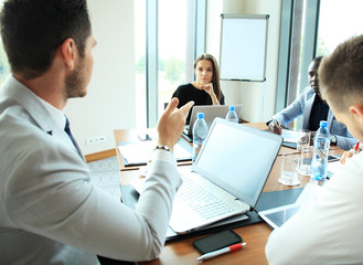 Obraz premium startup business team on meeting in modern bright office interior brainstorming, working on laptop and tablet computer.