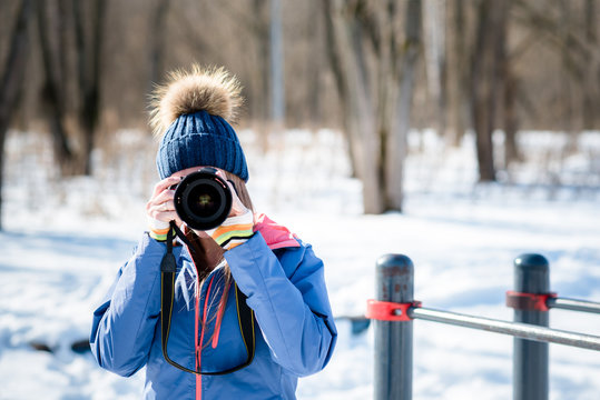 Woman photographer in winter forest