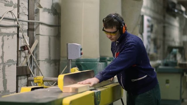 Carpenter working on sawing table in workshop
