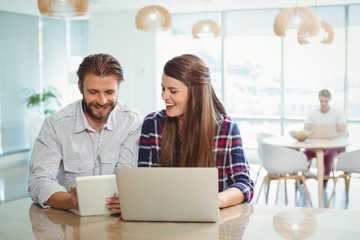 Executives using digital tablet and laptop