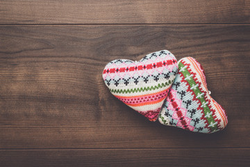 two knitted heart shapes on the wooden table