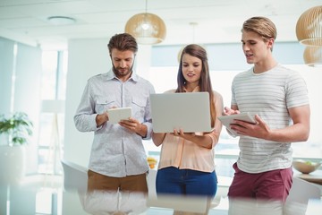 Attentive executives using digital tablet and laptop