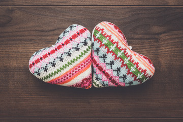 two knitted heart shapes on the wooden table
