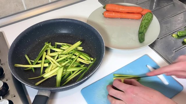 Time lapse of female hands make slices of carrots and zucchini