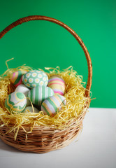Basket with colorful Easter eggs, close up photo