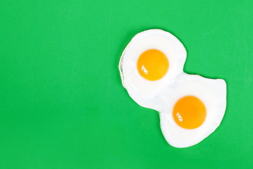 fried eggs fried eggs from two eggs on a green background