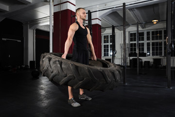 Obraz premium Man Doing Exercise With Tire