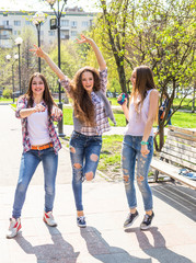 Happy teenage girls having fun in summer sunny park. Spring hot weather