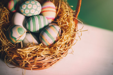 Basket with colorful Easter eggs, close up photo