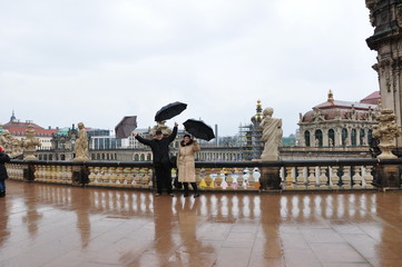 happy couple, woman and man with umbrella in rainy Dresden