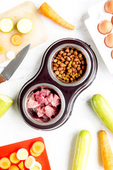 Dogfood set with cut vegetables and knife on table background top view