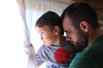 father and son looking throw the window