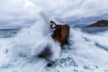 Fototapeta na wymiar Waves splashing in El peine de los vientos, Chillida's sculpture sited in Donostia, Spain, on March 2017