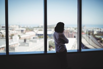 Female executive looking through window