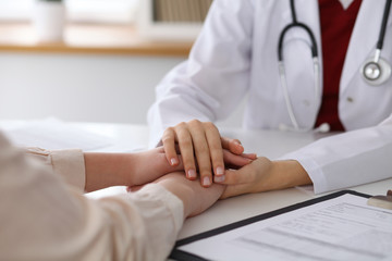 Hand of doctor  reassuring her female patient. Medical ethics and trust concept - 139996993