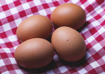Eggs on red and white tablecloth. Horizontal shoot.