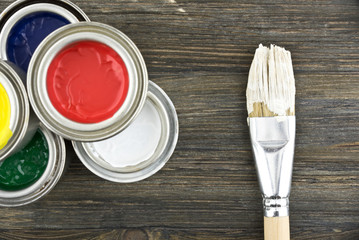 Jar of paint and brush on a wood background