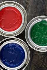 Jars of paint on a wooden background