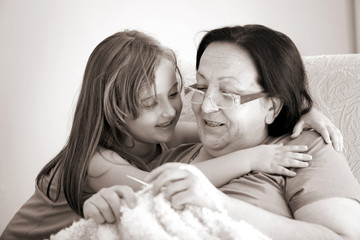 Granddaughter is kissing her grandmother.