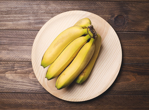 Bananas on a wooden plate. Food. Horizontal shoot.