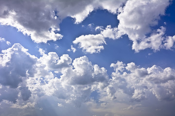 Clouds against a blue sky in a sunny day.
Clouds lit by the rays of the sun.