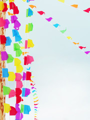 Garlands of bright multicolored flags against the sky. Vertical and diagonal arrangement of flags