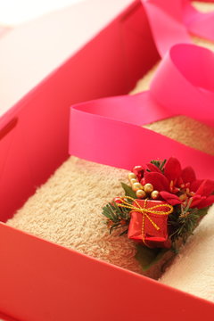 beige color towel in red box with decoration for Christmas present image