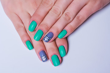 Nail art in turquoise with white cat on grey