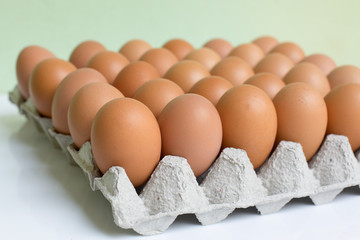 rown and white eggs arranged in a tray viewed from above, representing simplicity, freshness, and...