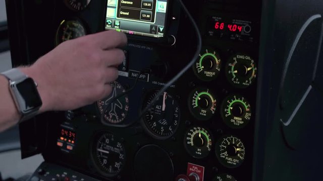 CLOSE UP: A helicopter pilot manipulates the helicopter flight controls to achieve and maintain controlled aerodynamic flight. Pilot adjusting the settings to take off in a chopper and start a journey