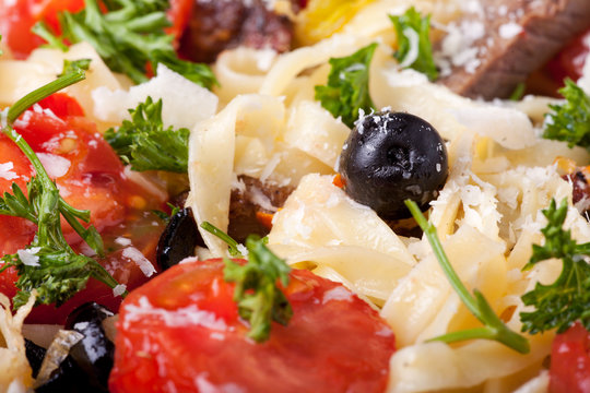 Nahaufnahme von frischer Pasta mit Tomaten und Oliven