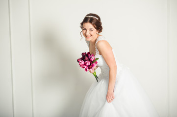 Smiling bride holding big wedding bouquet