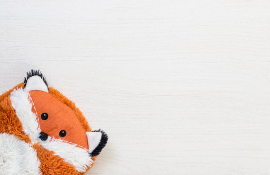 Fox plush cuddly toy orange on white wooden desk background