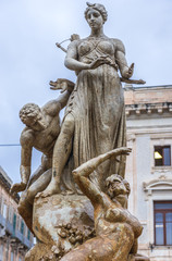 Fototapeta na wymiar Famous Artemis (Diana) Fountain on Archimedes Square on the Ortygia isle - old town of Syracuse on Sicily island, Italy