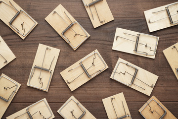 many mousetraps on the brown wooden background