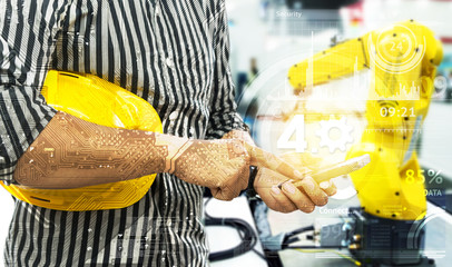 Industry 4.0 internet of things concept. Engineer finger point to smart phone for control blur robot machine arm background , yellow hat and industrial graphic in smart factory.