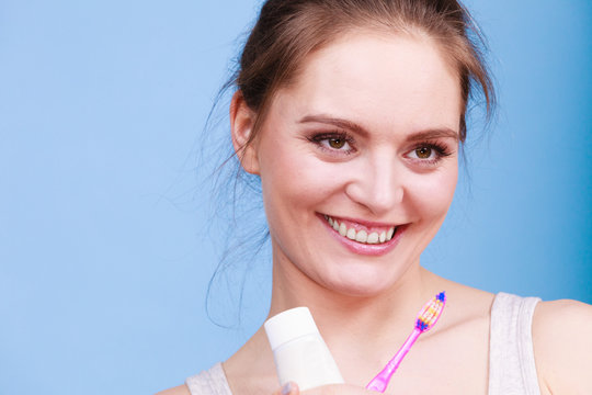 Woman holds toothbrush and paste for teeth cleaning