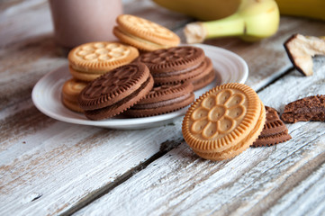 Photo of fresh Made Chocolate Banana Smoothie on a wooden table with cookies.