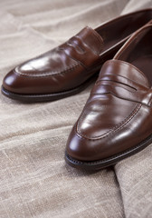 Shoes Concepts and Ideas. Closeup of Stylish Modern Brown Leather Penny Loafer Shoes On Mesh Surface.