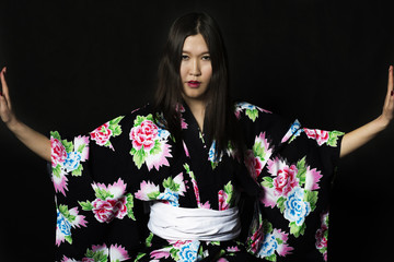 Japanese girl in traditional Japanese kimono on black background.
