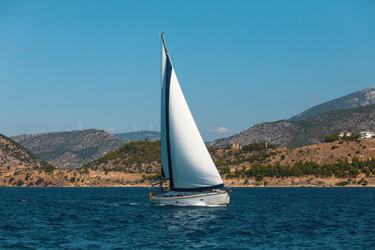 Sailing boat yacht on blue water Sea.