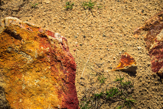 Red and Orange Rocks on Sandy Soil