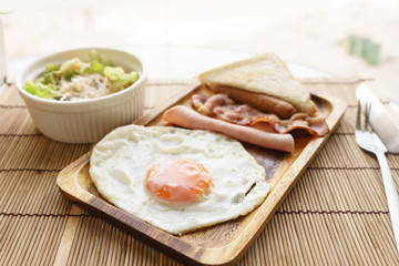 american breakfast beautiful fried egg on wood dish with vegetable salad