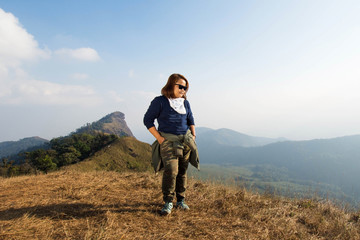 Naklejka na ściany i meble happy woman smile and stand on top mountain at morning light, subject is soft focus