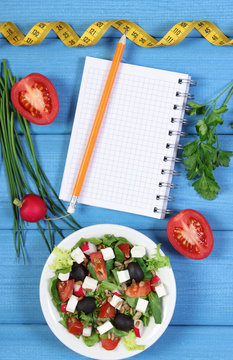 Greek salad with vegetables, centimeter and notepad for notes, healthy food and slimming concept