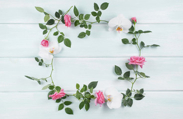 Wooden background with floral frame consists of roses and orchid flowers